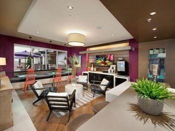 A hotel lobby with purple walls and a white table and chairs